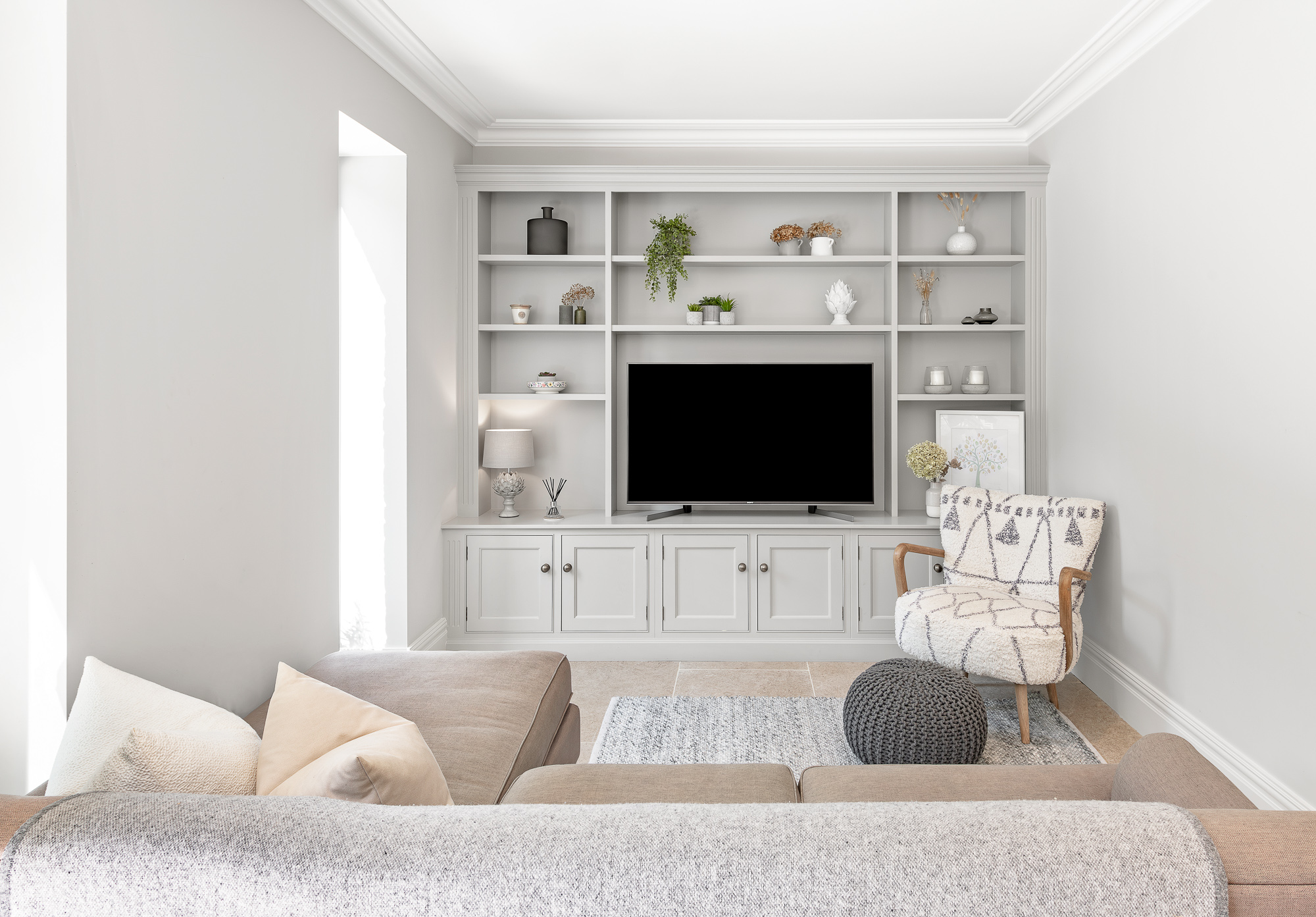 Light painted fitted media cabinetry with open shelving and cupboards