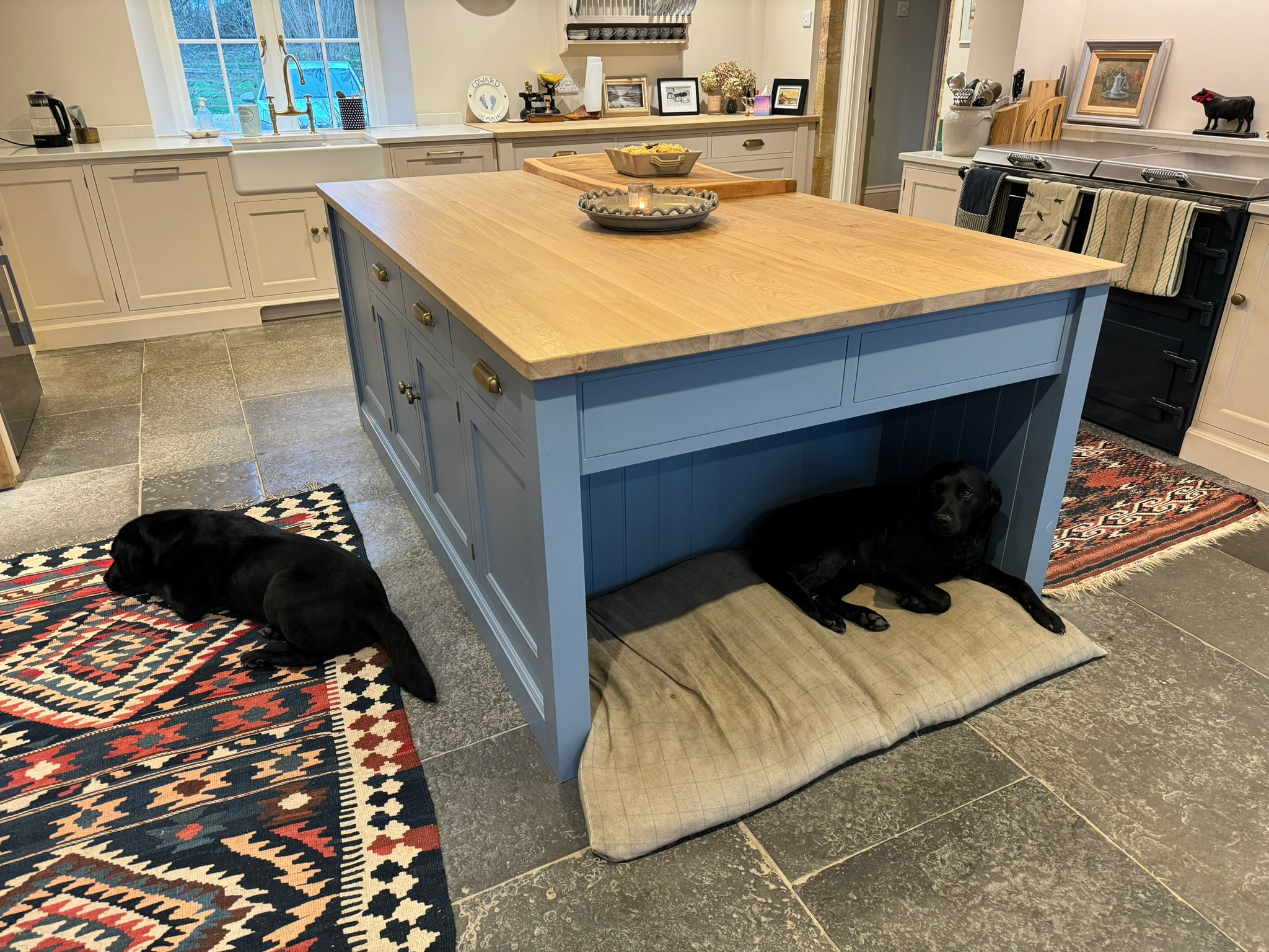 Blue painted kitchen island incorporating a sheltered dog bed