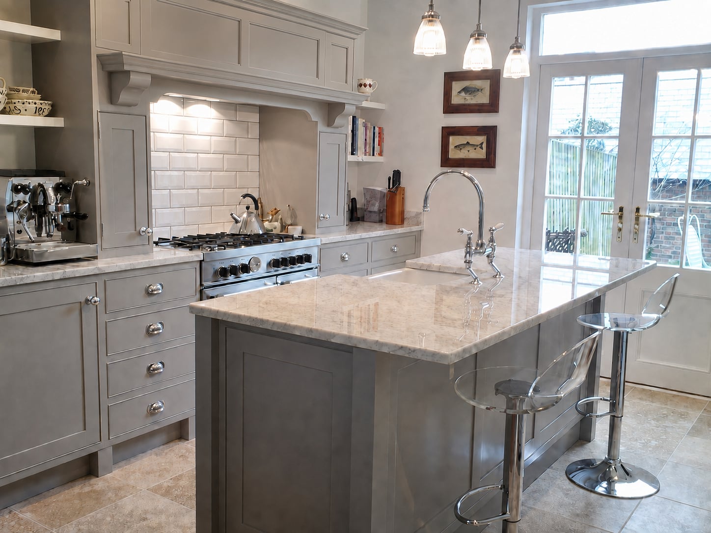 Grey painted kitchen with a marble island, range cooker and glazed garden doors