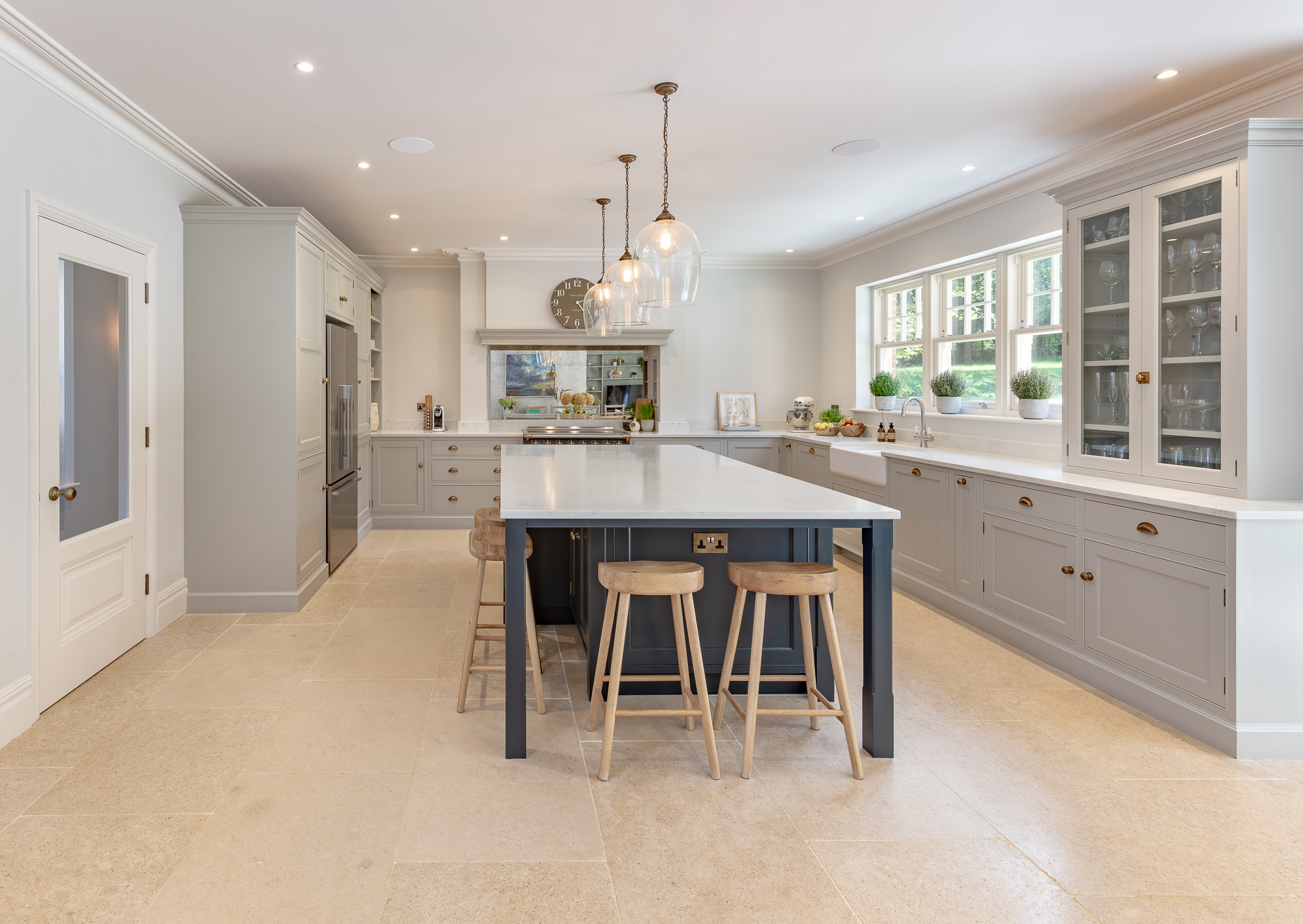Spacious grey painted kitchen with a dark island and pendant lighting